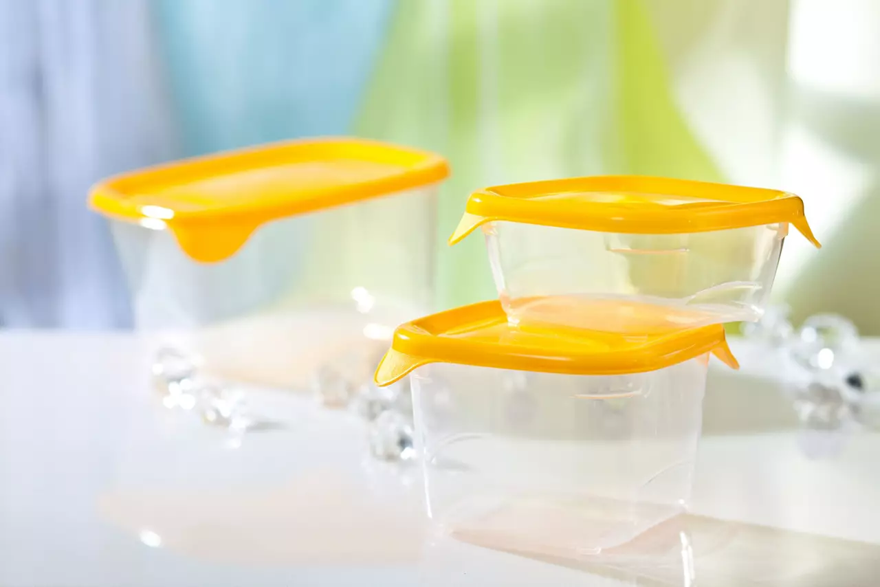 Empty clear plastic food containers with yellow lids