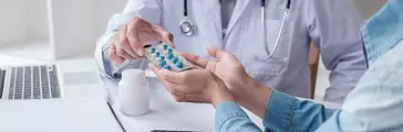 Doctor giving pills to a patient in clinic. Concept of healthcare, medical treatment and insurance