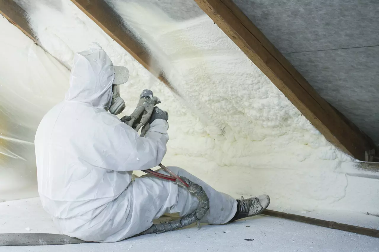 Worker spraying polyurethane foam on the inside of the roof 