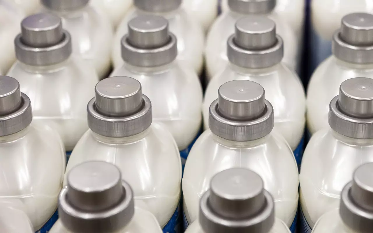 Plastic bottles with fabric softener in store. Gray screw caps. Color plastic bottles in a row. Store shelf. Fresh linen.