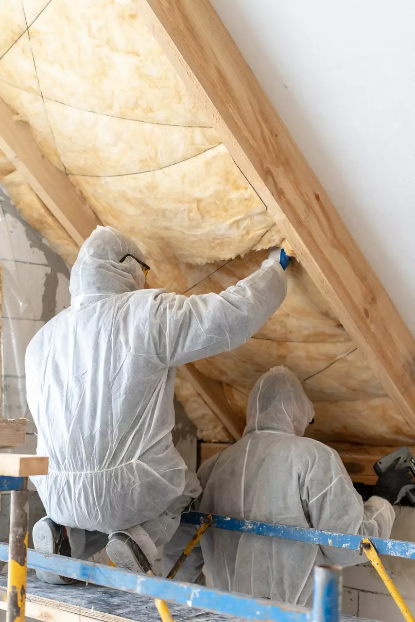  workers installing thermal insulation rock wool under the roof