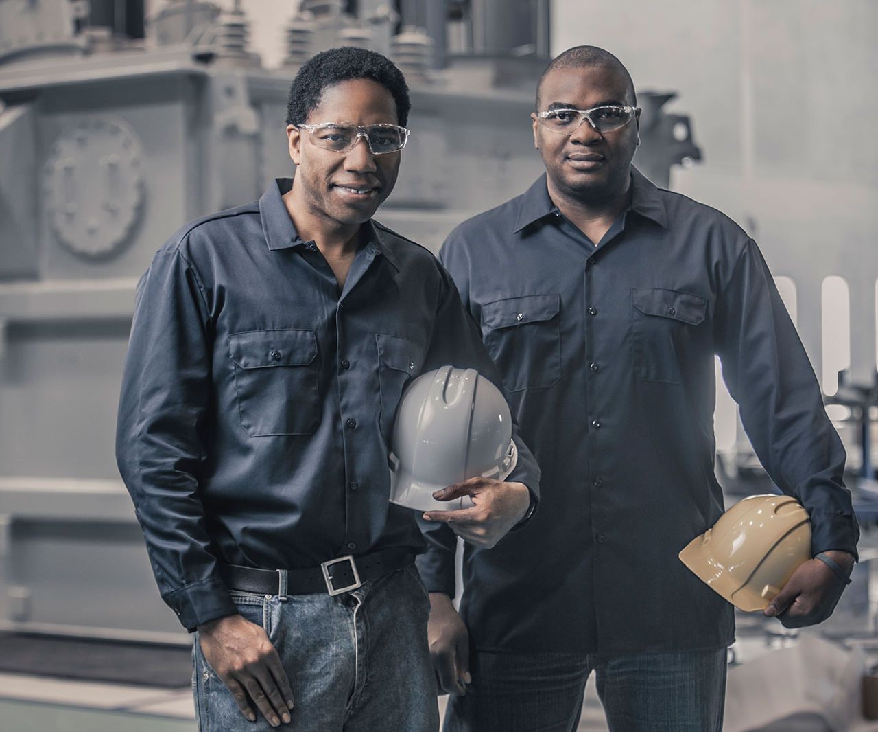 two workers holding hard hats