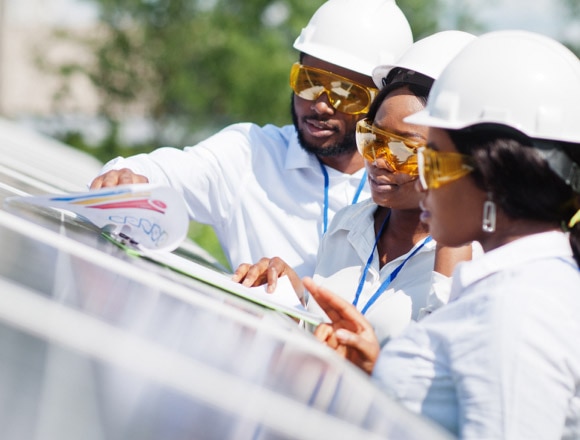 Colleagues wearing white shirts and safety helmets meet