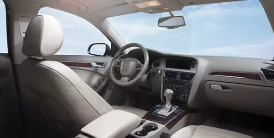 Interior of car behind front seats showing the dashboard and sky